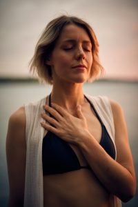 Woman with Hand on Chest and Eyes Closed Deep Breathing