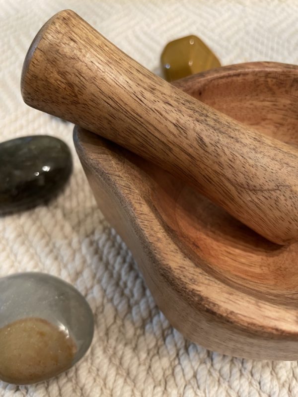 Close Up View of Wooden Mortar + Pestle Set with Palm Stones in Background - SBB